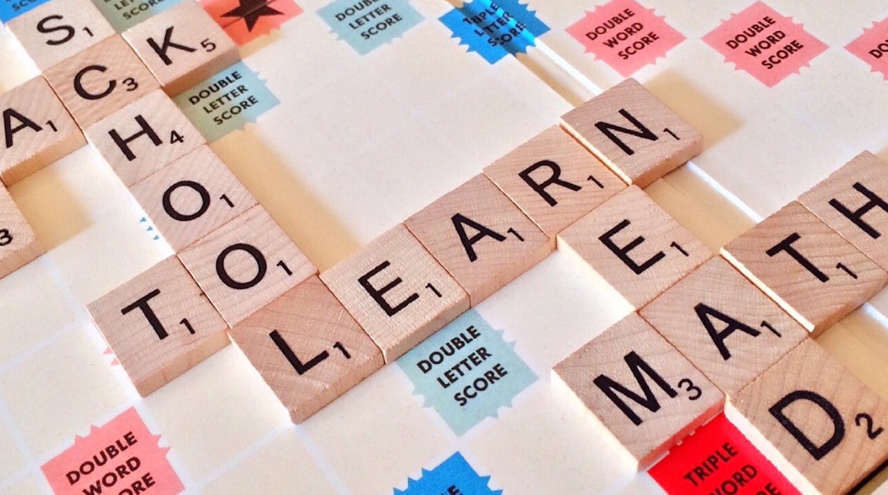hero-img-01 Close-up of Scrabble tiles forming words related to education and school.